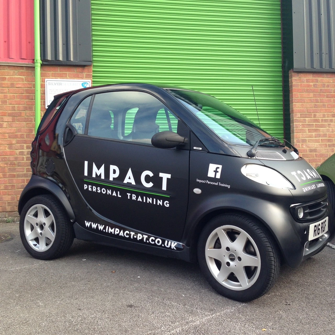 Side view of the Impact Personal Training Smart car, showing the door lettering and web address