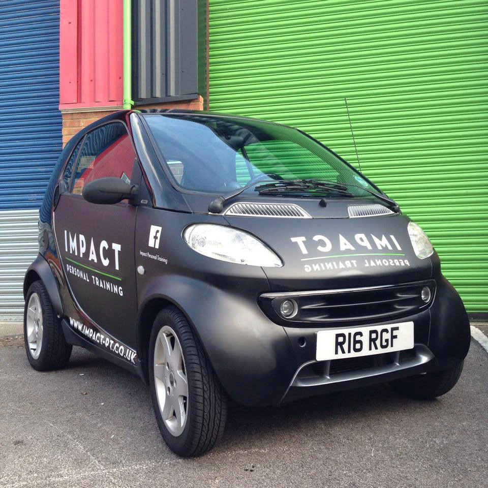Black Impact Personal Training Smart car with white lettering and lime green details