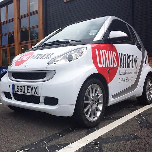 White Luxus Kitchens Smart car with red and black graphics produced and fitted from an agency-supplied design